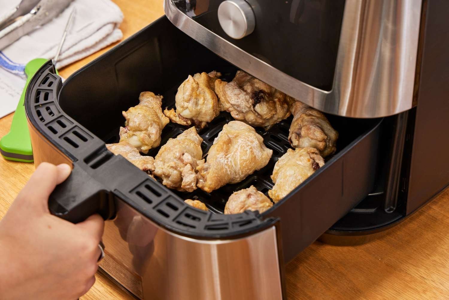 The internal components of an air fryer including the heating element and perforated basket.