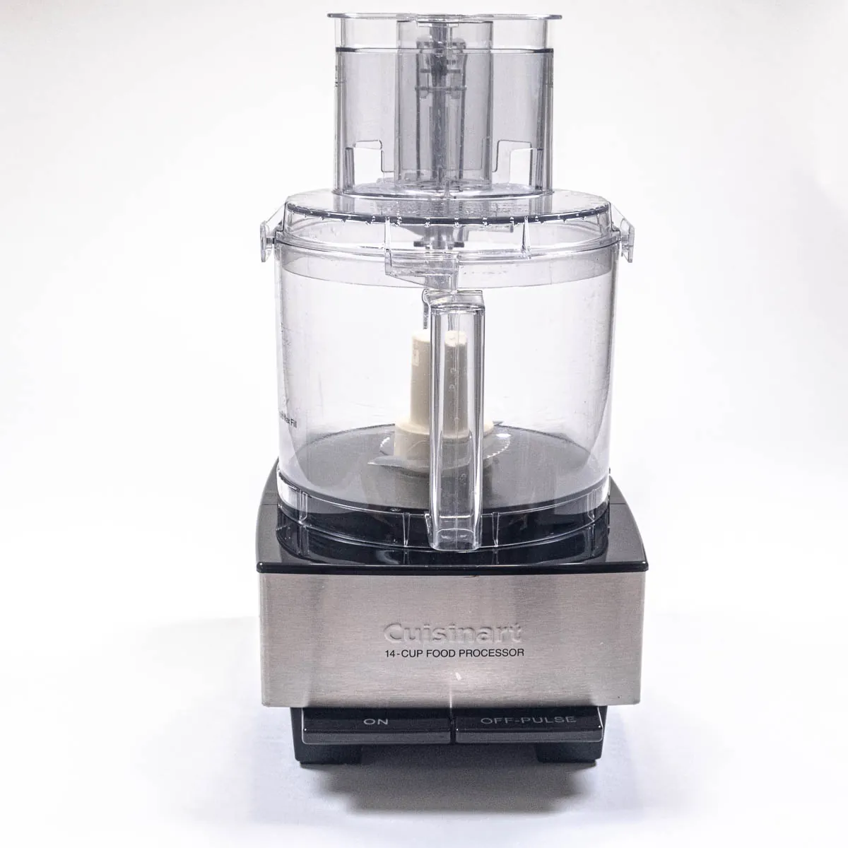 Inside view of a food processor bowl showing the S-blade and chopped vegetable pieces.