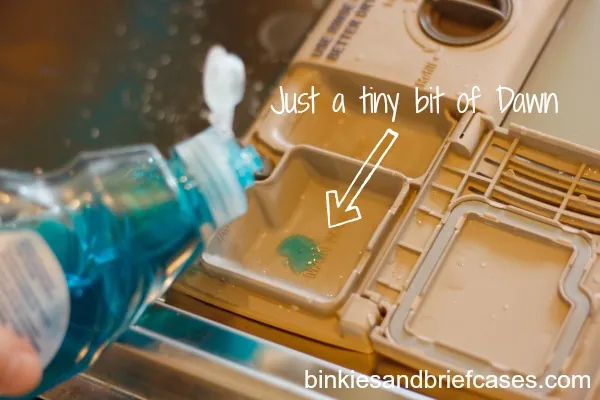 Loading a clean plate into the dishwasher after scraping off food scraps.