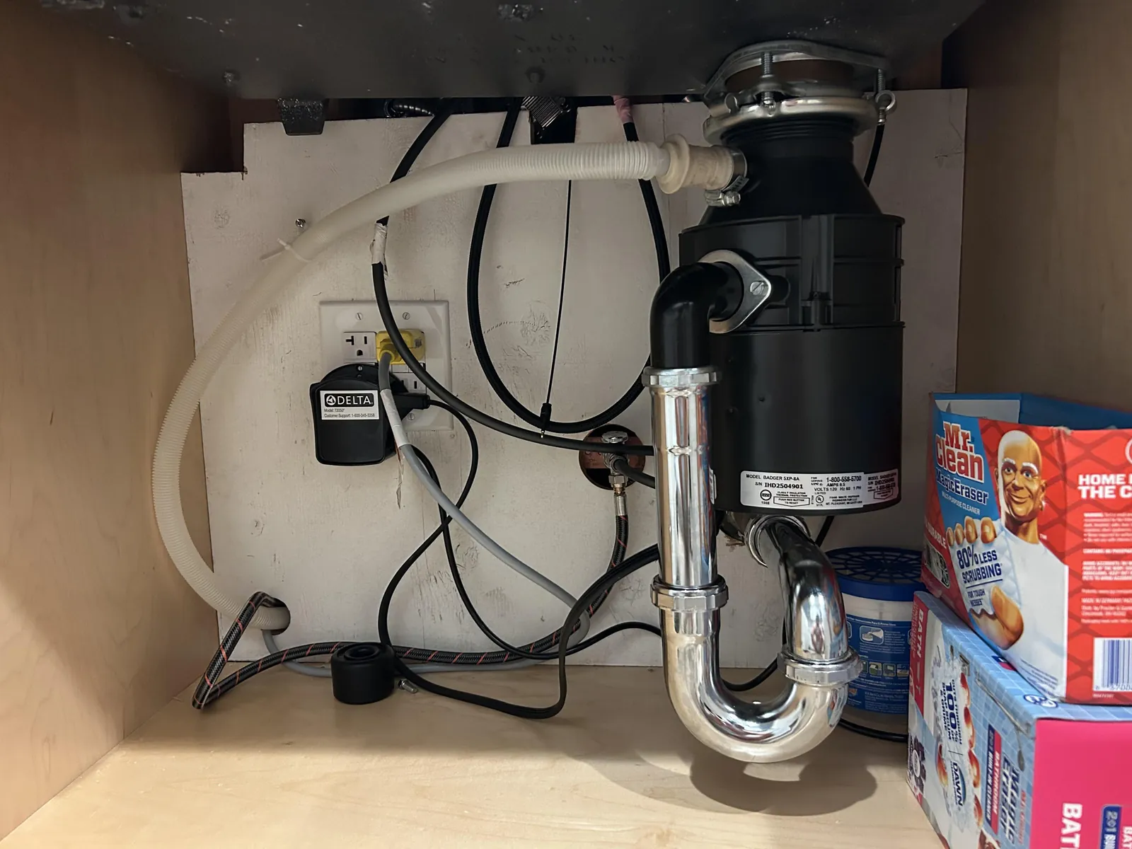 Removing the cap from a dishwasher air gap for routine maintenance inspection.