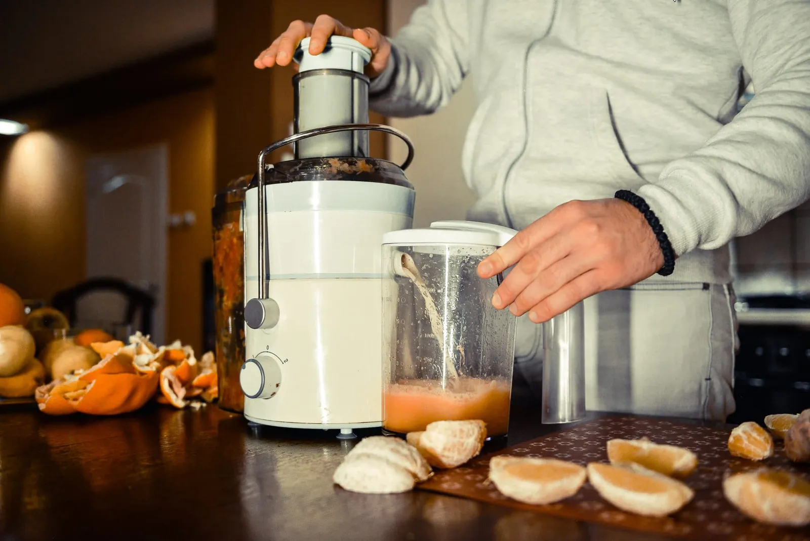 Rinsing a juicer mesh filter under running water to remove stubborn fruit pulp.