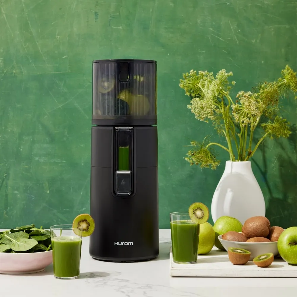 The simple, accessible components of a centrifugal juicer laid out on a board.